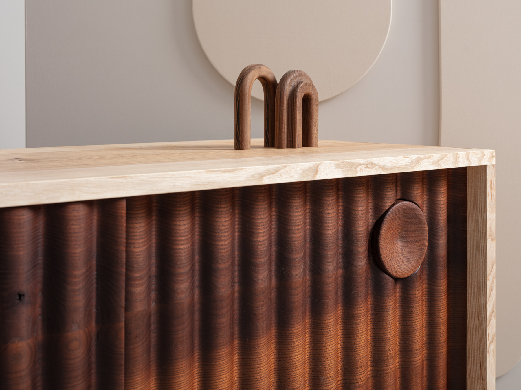 Bowater Media Unit, the signature ripple facade is digitally profiled from brown oak, hand-turned leg and handle details with a removable base, The carcass is made from solid timber with dovetail joinery