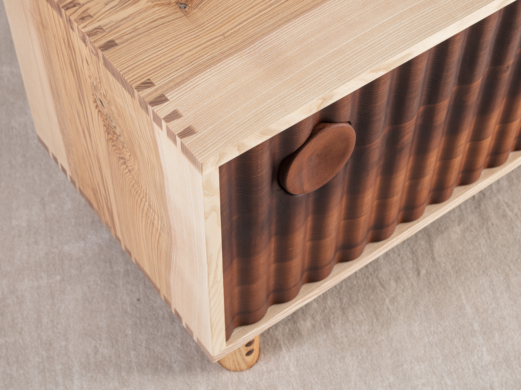 Bowater Media Unit, the signature ripple facade is digitally profiled from brown oak, hand-turned leg and handle details with a removable base, The carcass is made from solid timber with dovetail joinery