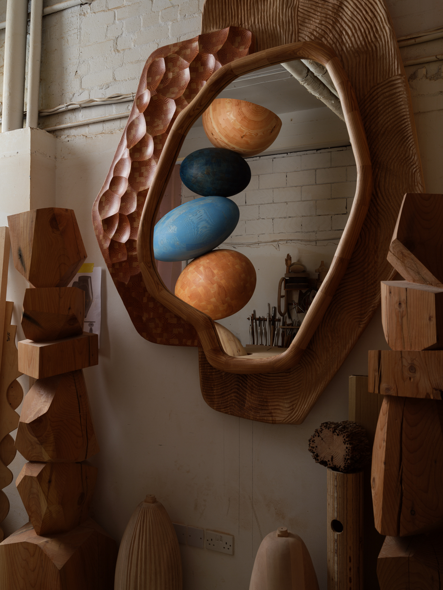 jan hendzel studio's wooden sculpture for park avenue hotel in new york view of stacked timber reflection in mirror