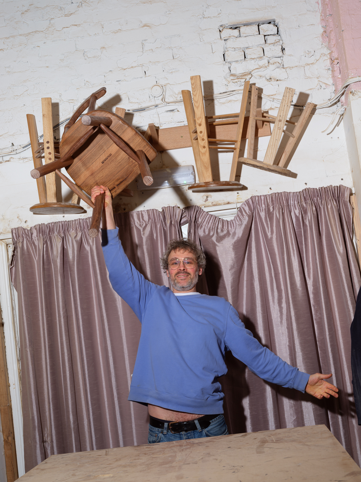 Jan Hendzel celebrates holding chair in studio setting.